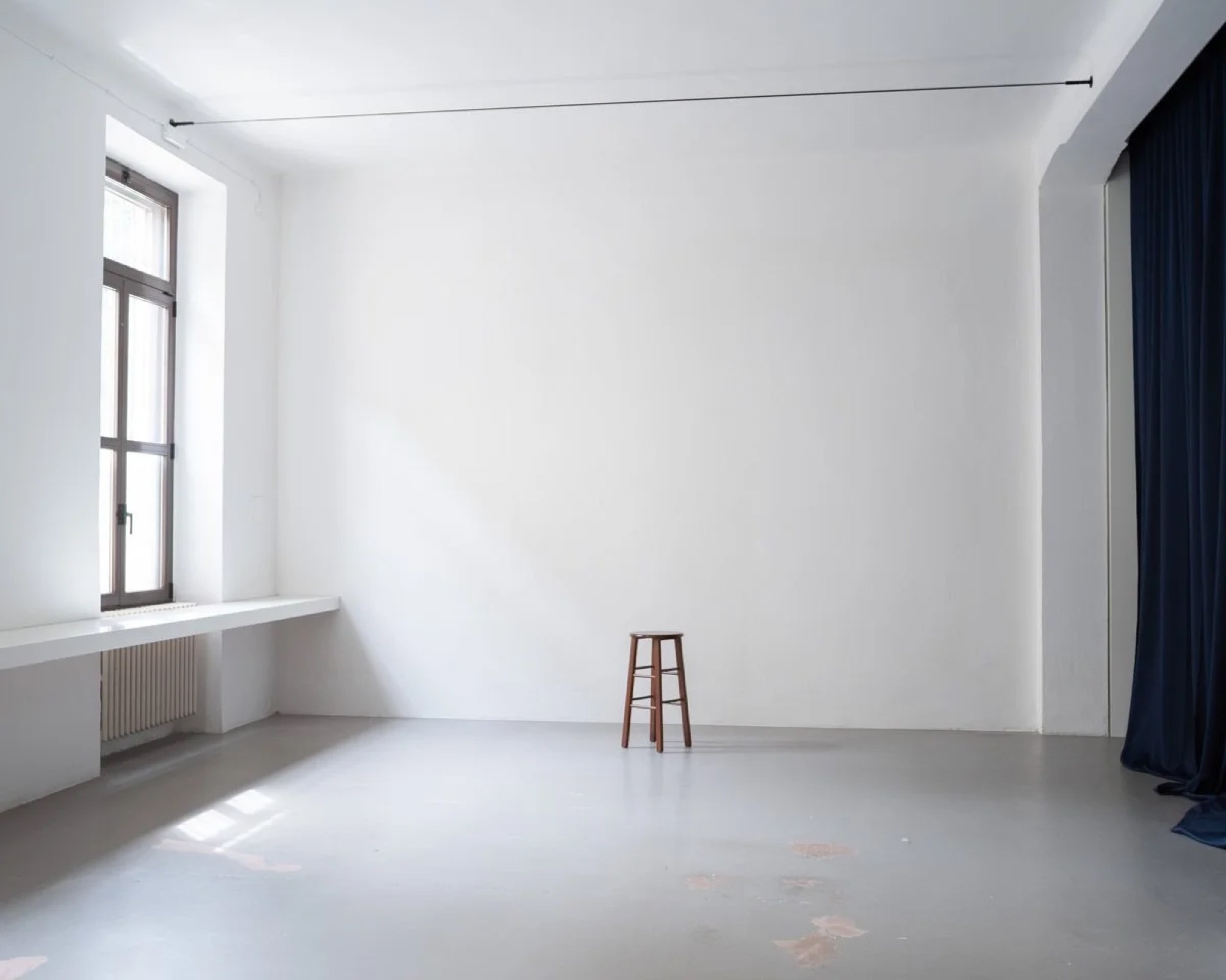 Sala principale dello studio, pareti bianche e tende blu